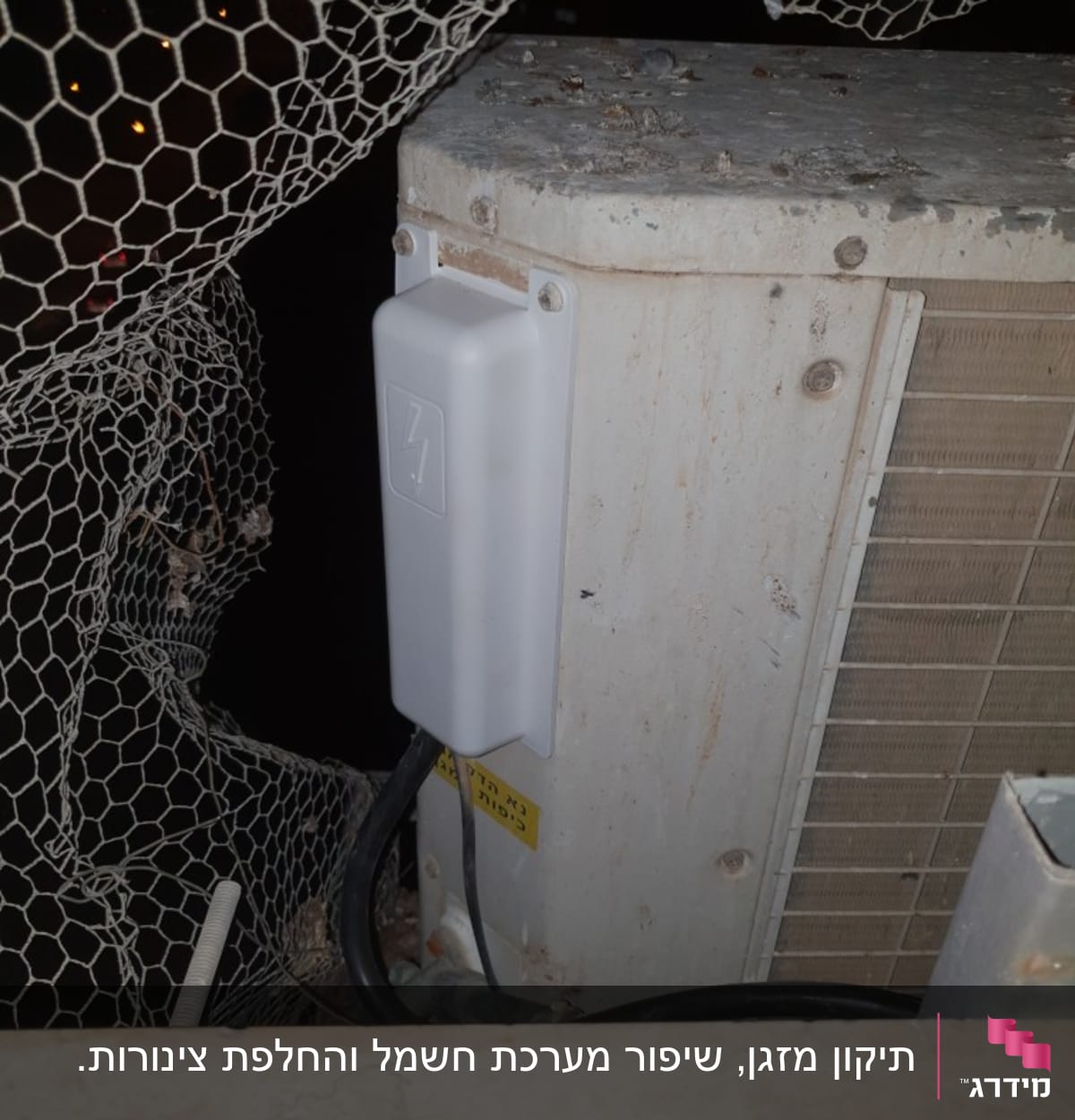 יחידת מזגן חיצונית עם כבלים ורשת הגנה